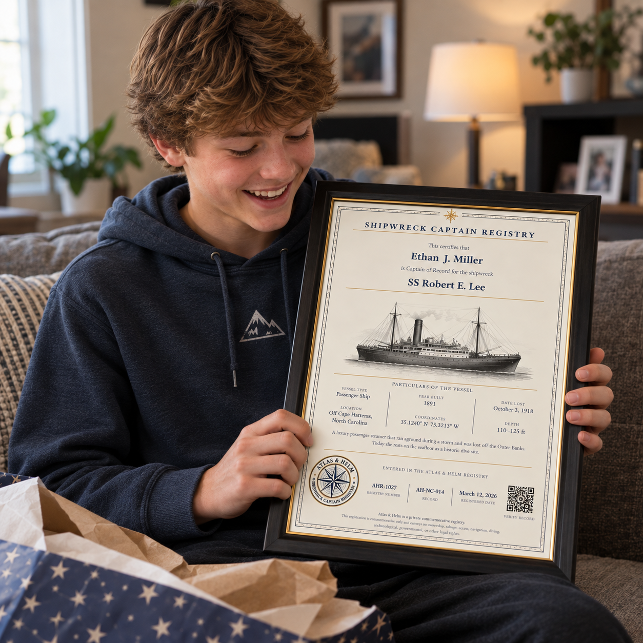 A teenager holding his framed Shipwreck Captain certificate